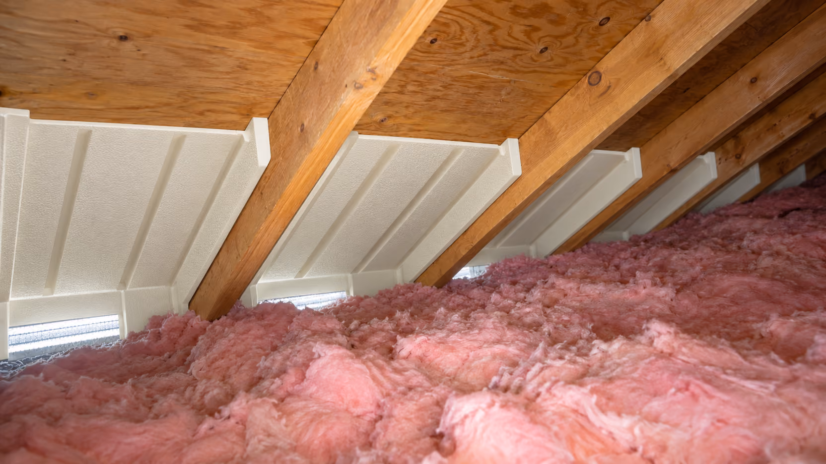 Attic at the eaves with baffles between rafters holding insulation back from the soffit vents, Anchorage